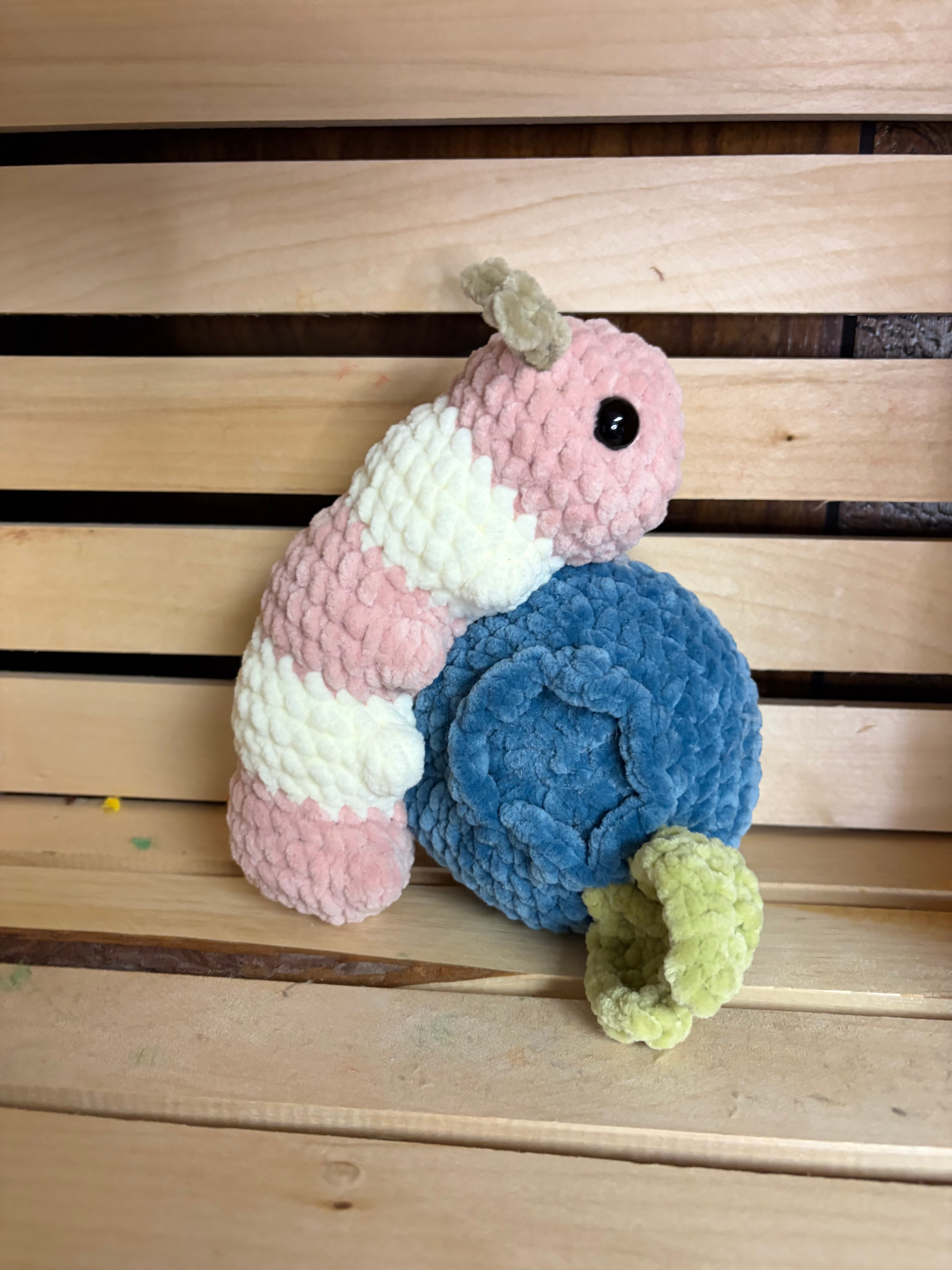 crochet caterpillar on a blueberry plush